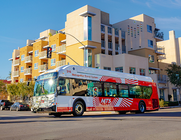 Bus on the street with an apartment building in the background