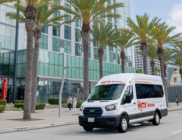 White MTS Access vehicle in front of a row of palm trees