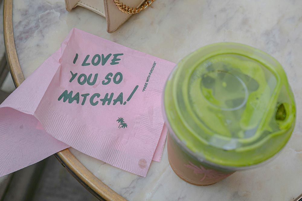 Pink napkin that says I love you so matcha! with a green drink to the side