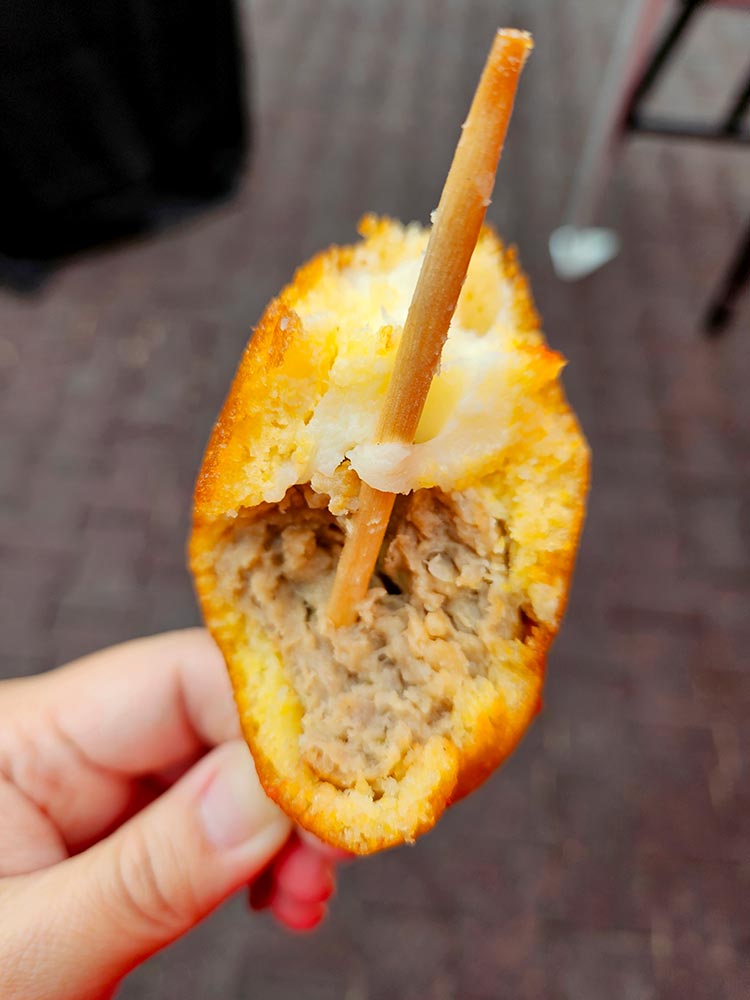 Meatball and mozzarella on a stick within a batter.