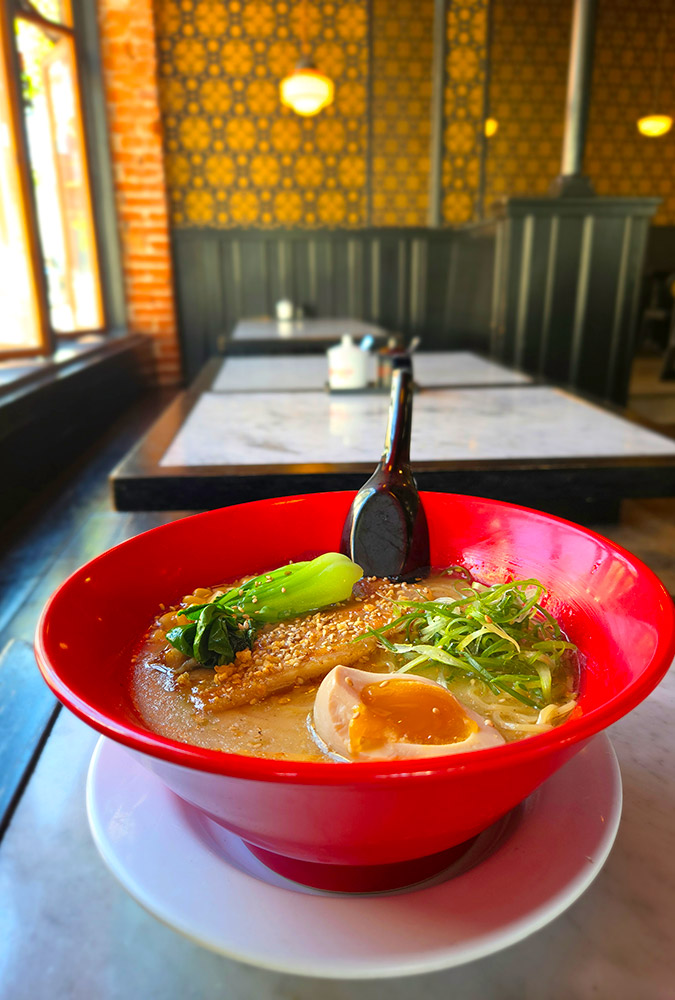 Bowl of ramen sitting on a table inside of a restaurant