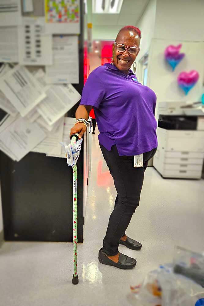 Corrina Guyton, Transit Store Clerk, helps display one of the canes turned in to Lost and Found.