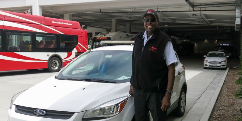 Lewis stands next to a road supervisor car