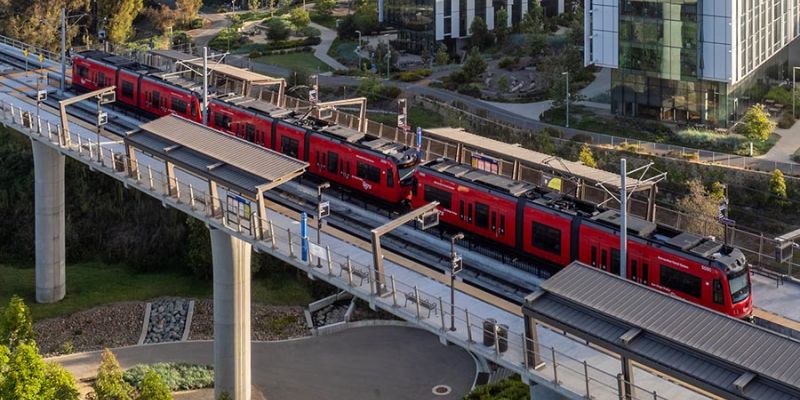 Trolley on an elevated platform with buildings in the background