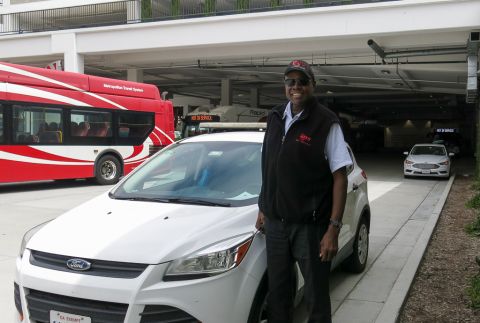 Lewis stands next to a road supervisor car