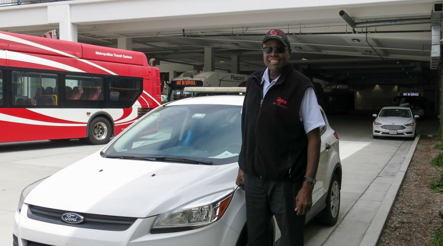 Lewis stands next to a road supervisor car