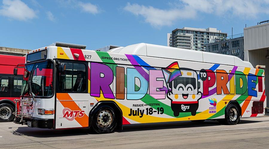 MTS Bus wrapped with a rainbow, the Bus mascot, and says Ride to Pride